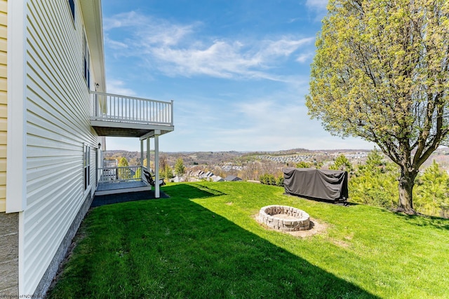 view of yard with a fire pit and a balcony