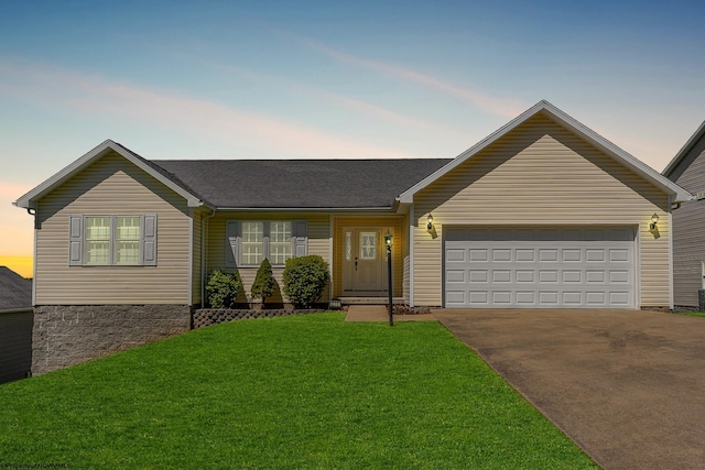 single story home with an attached garage, driveway, and a yard