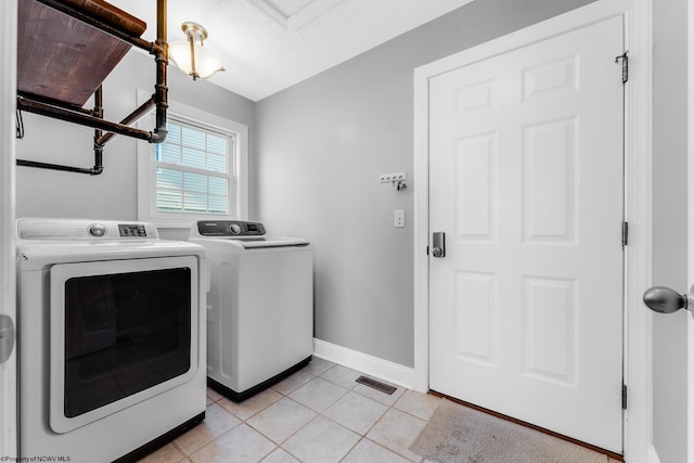 laundry room with light tile patterned flooring, washer and dryer, laundry area, baseboards, and visible vents