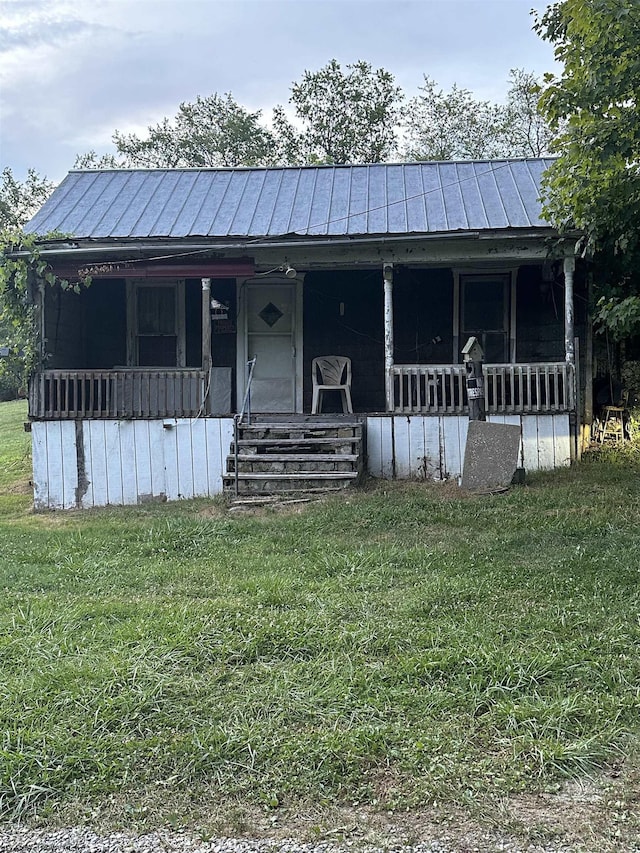view of front of home featuring a standing seam roof, a front yard, and covered porch