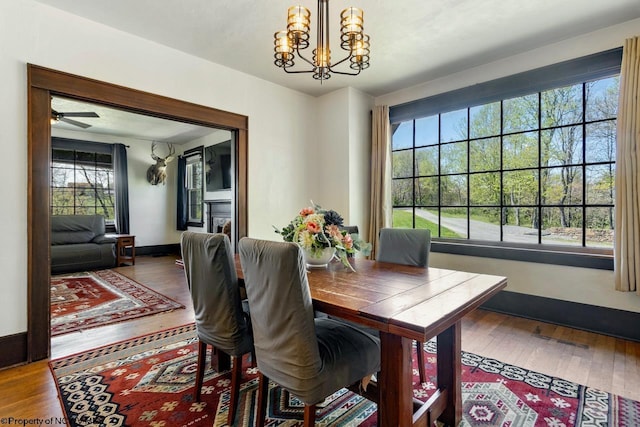 1042 Fort Martin Rd, Maidsville, WV 26541 - dining room featuring ceiling fan with notable chandelier, wood finished floors, and a healthy amount of sunlight