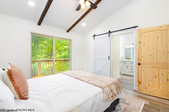 bedroom featuring recessed lighting, vaulted ceiling with beams, ensuite bath, light wood-style flooring, and a barn door