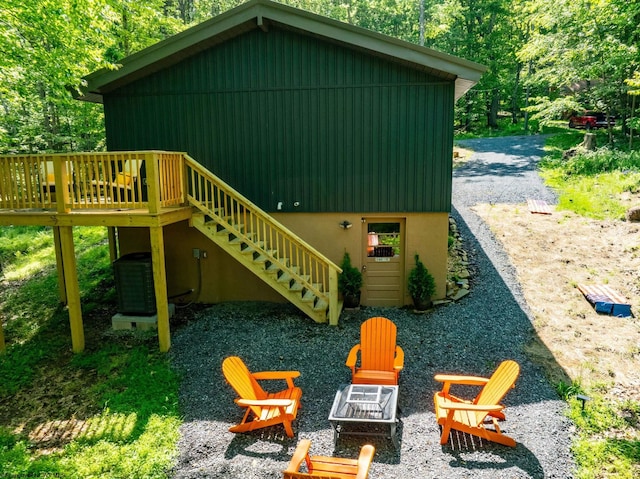 view of jungle gym with a fire pit, a deck, central AC, and stairway