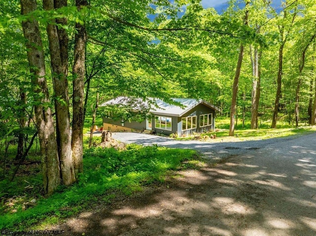 rustic home featuring metal roof and a view of trees