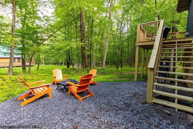 view of jungle gym featuring stairway, a wooden deck, and an outdoor fire pit
