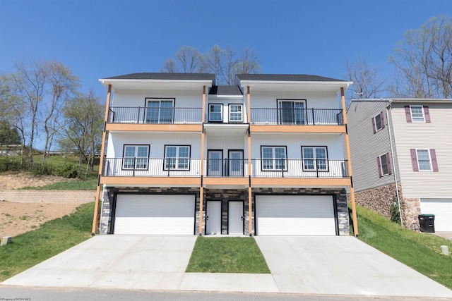 69 Hall Valley Ct, Bridgeport, WV 26330 - view of front facade featuring concrete driveway, a balcony, an attached garage, and stone siding