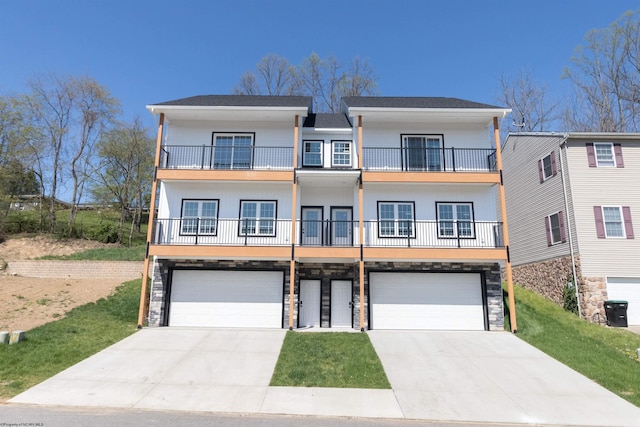 view of front of house with stone siding, a balcony, and a garage