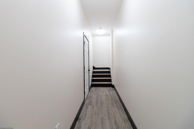 hall featuring baseboards and light wood-type flooring
