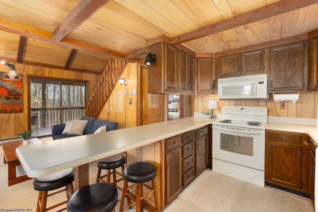 kitchen with beamed ceiling, wooden ceiling, a peninsula, wood walls, and white appliances