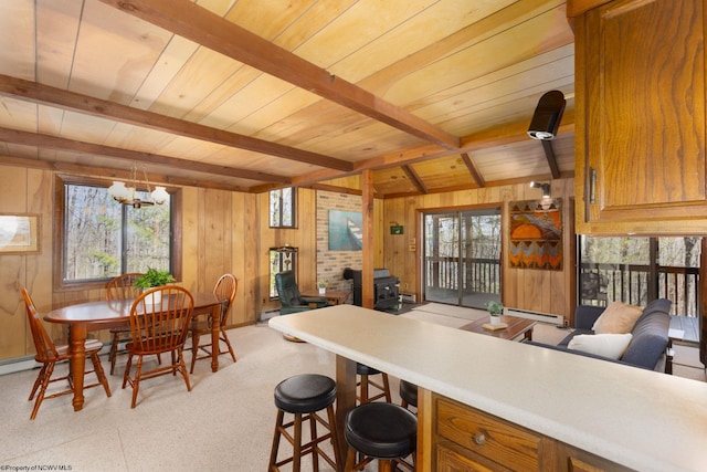 kitchen featuring beam ceiling, wooden ceiling, a notable chandelier, and a baseboard heating unit