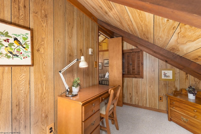 carpeted office featuring wooden walls and vaulted ceiling