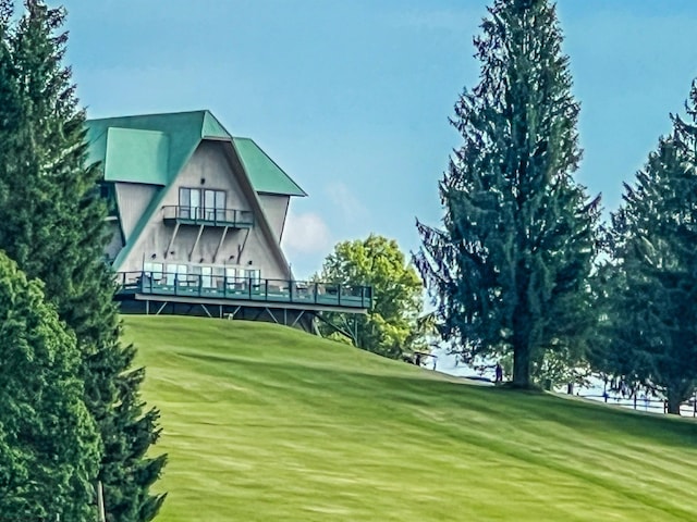 view of home's community with a lawn, a deck, and golf course view