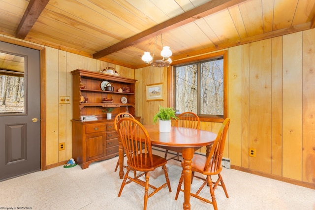 dining room featuring beamed ceiling, wood walls, a chandelier, wooden ceiling, and light carpet