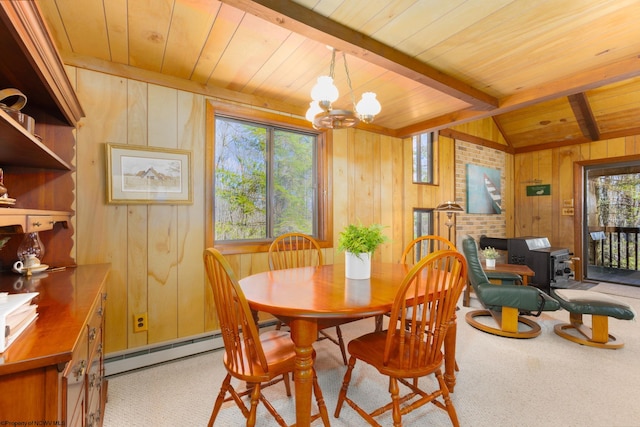 carpeted dining area featuring wood walls, wooden ceiling, and a wealth of natural light