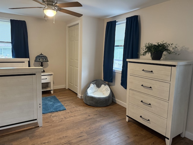 bedroom featuring baseboards, wood finished floors, and a ceiling fan