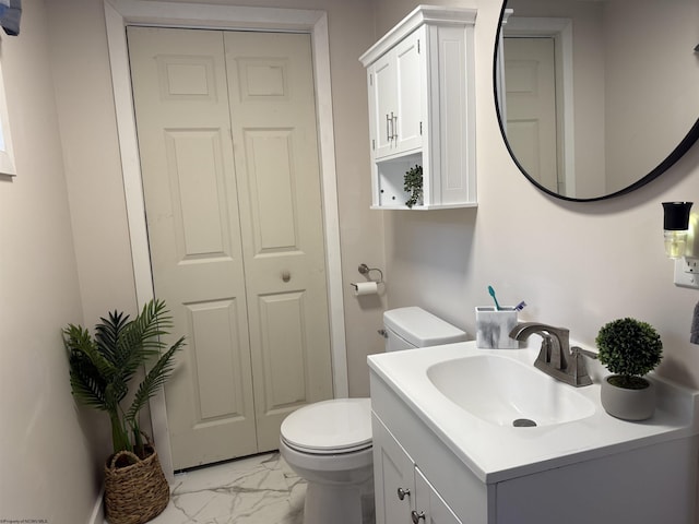 bathroom featuring toilet, marble finish floor, a closet, and vanity