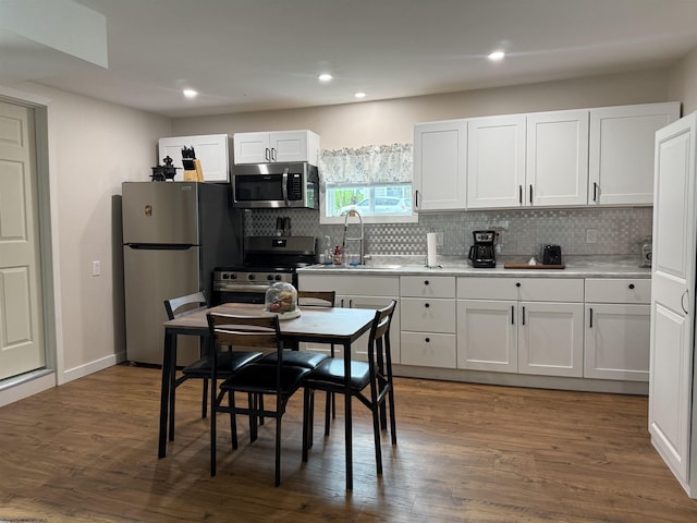 kitchen featuring recessed lighting, appliances with stainless steel finishes, white cabinets, backsplash, and a sink