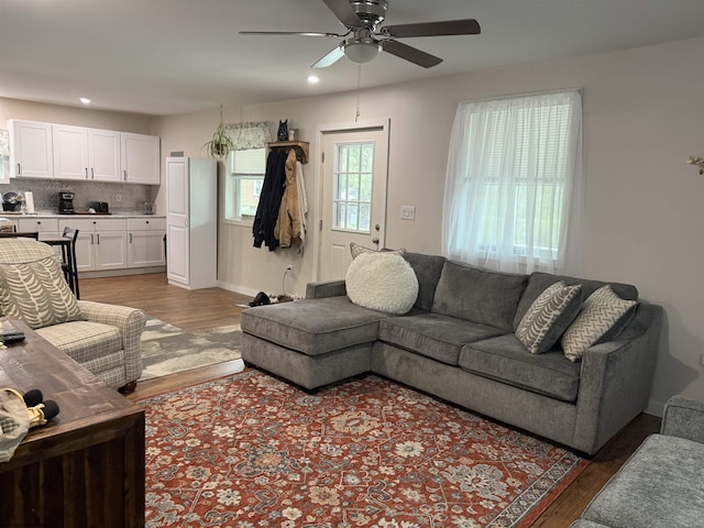 living area featuring recessed lighting, a ceiling fan, baseboards, and light wood-type flooring
