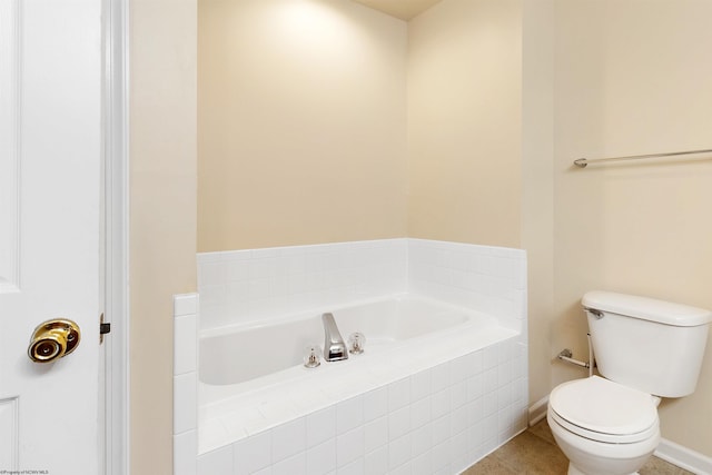 bathroom featuring toilet, a bath, tile patterned floors, and baseboards