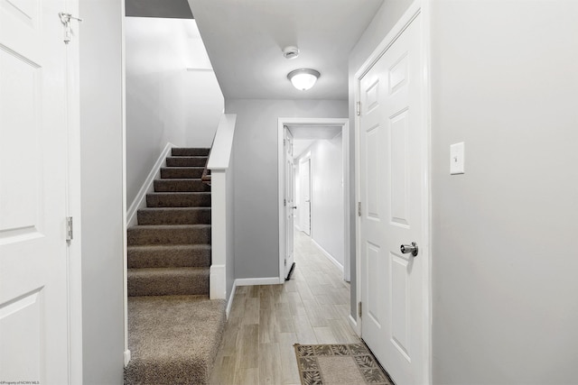 interior space featuring light wood finished floors, stairs, and baseboards