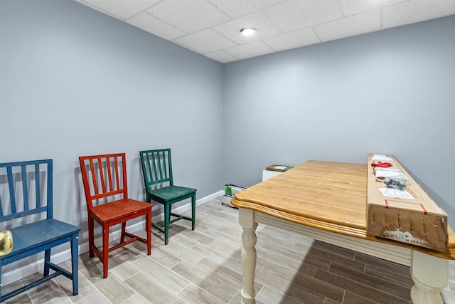 office space with baseboards, wood tiled floor, and a drop ceiling