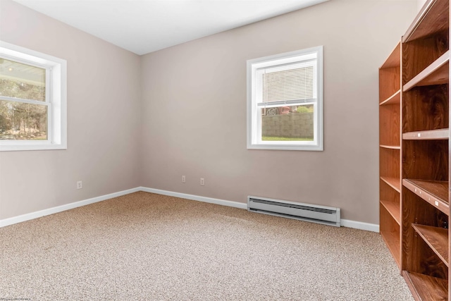 empty room with baseboards, baseboard heating, and carpet floors