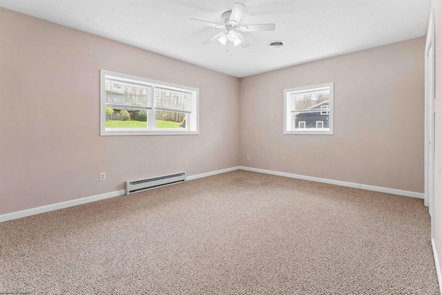 carpeted empty room with a ceiling fan, visible vents, plenty of natural light, and baseboard heating