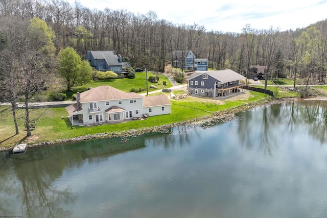 birds eye view of property featuring a water view and a wooded view