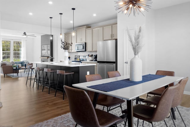 dining area featuring recessed lighting, light wood finished floors, and ceiling fan with notable chandelier