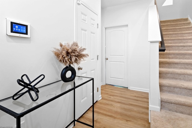 interior space featuring stairway, light wood finished floors, and baseboards