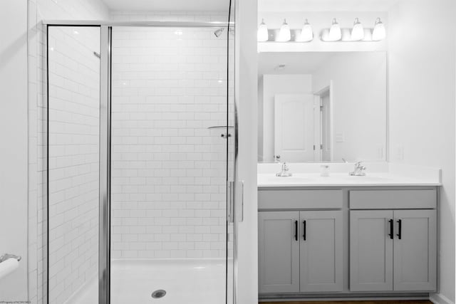 bathroom with double vanity, a sink, and a shower stall