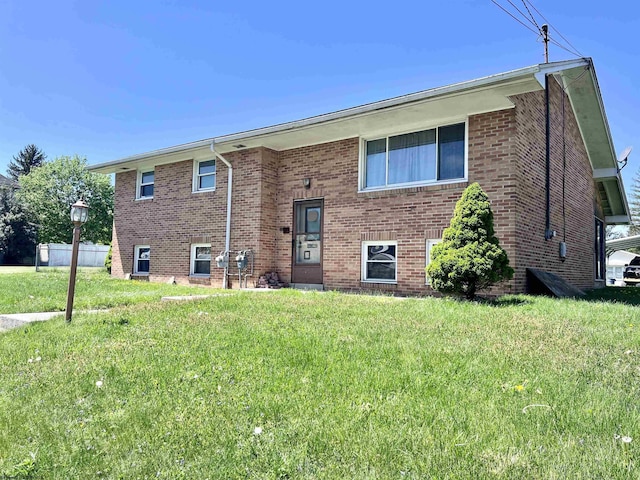 back of house with a yard and brick siding