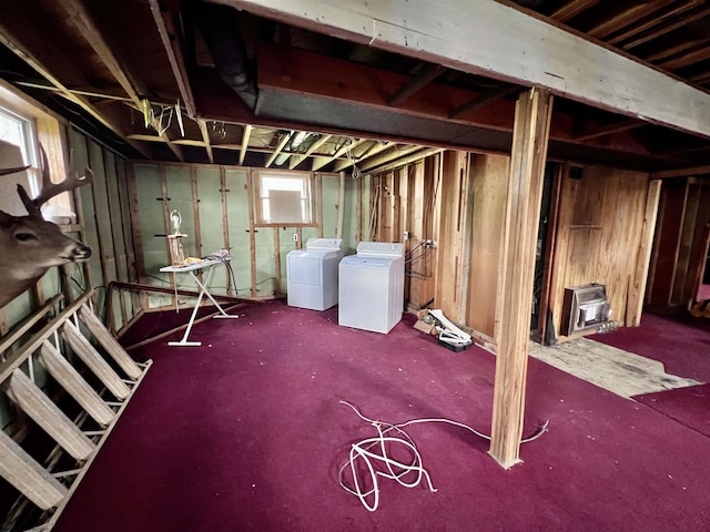 below grade area with heating unit, separate washer and dryer, and wooden walls