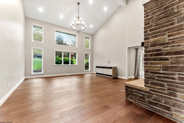 2254 Lakeside Ests, Morgantown, WV 26508 - unfurnished living room with dark wood-style flooring, high vaulted ceiling, a notable chandelier, and baseboards