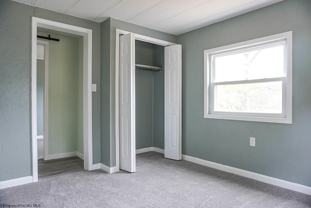 unfurnished bedroom featuring carpet flooring, baseboards, and a closet