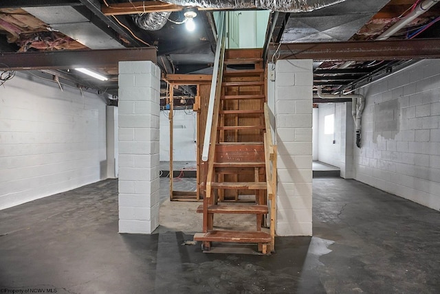 unfinished below grade area with concrete block wall and stairway
