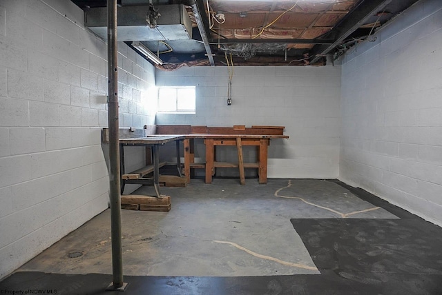 basement with concrete block wall and a workshop area