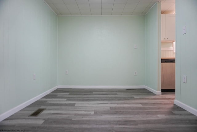 spare room featuring visible vents, baseboards, and wood finished floors