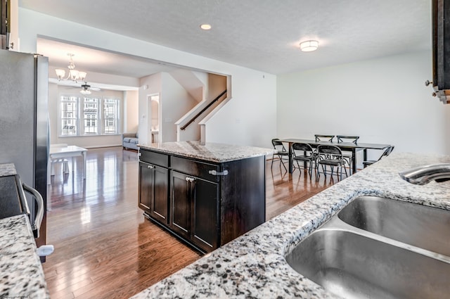 3005 Sun Vw, Morgantown, WV 26505 - kitchen featuring light stone countertops, a sink, freestanding refrigerator, open floor plan, and wood finished floors