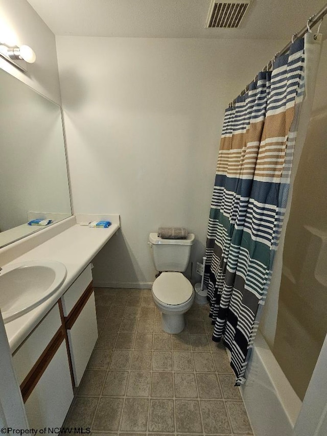 bathroom featuring visible vents, shower / bath combo, vanity, baseboards, and toilet
