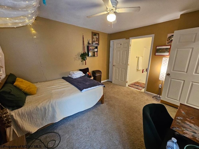 carpeted bedroom featuring baseboards, ceiling fan, and ensuite bath