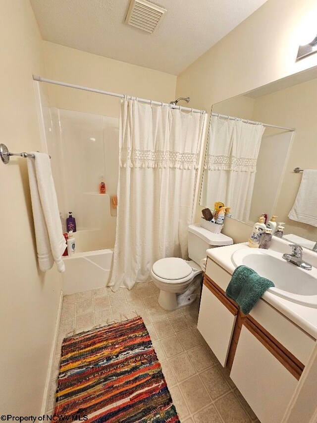 full bathroom with visible vents, vanity, tile patterned floors, toilet, and shower / bath combo with shower curtain