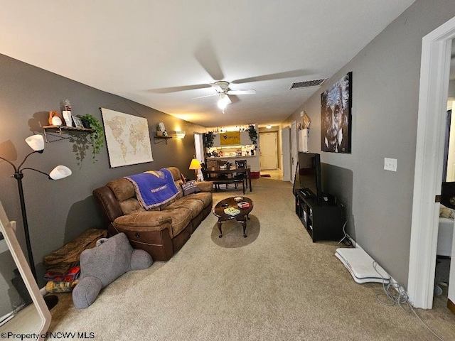 living room featuring light carpet, a ceiling fan, and visible vents