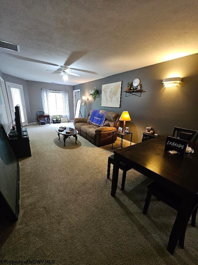 carpeted living area featuring a ceiling fan, a textured ceiling, and visible vents