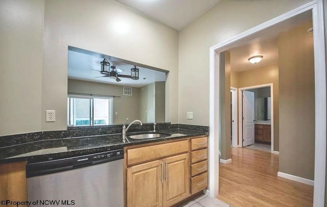 kitchen with a sink, dark stone counters, a ceiling fan, stainless steel dishwasher, and visible vents