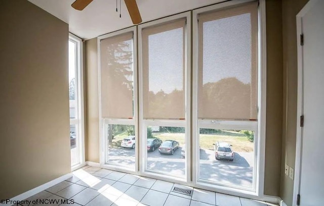 entryway featuring visible vents, baseboards, ceiling fan, and light tile patterned floors