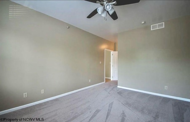 carpeted spare room featuring baseboards, ceiling fan, and visible vents