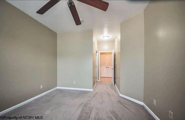 carpeted empty room featuring baseboards and ceiling fan