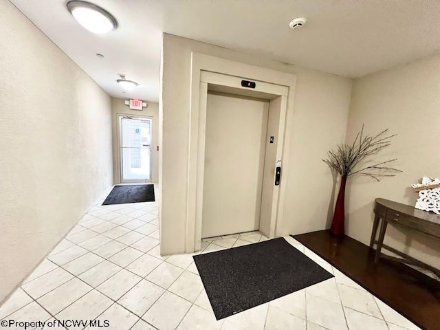 entryway featuring light tile patterned flooring and elevator