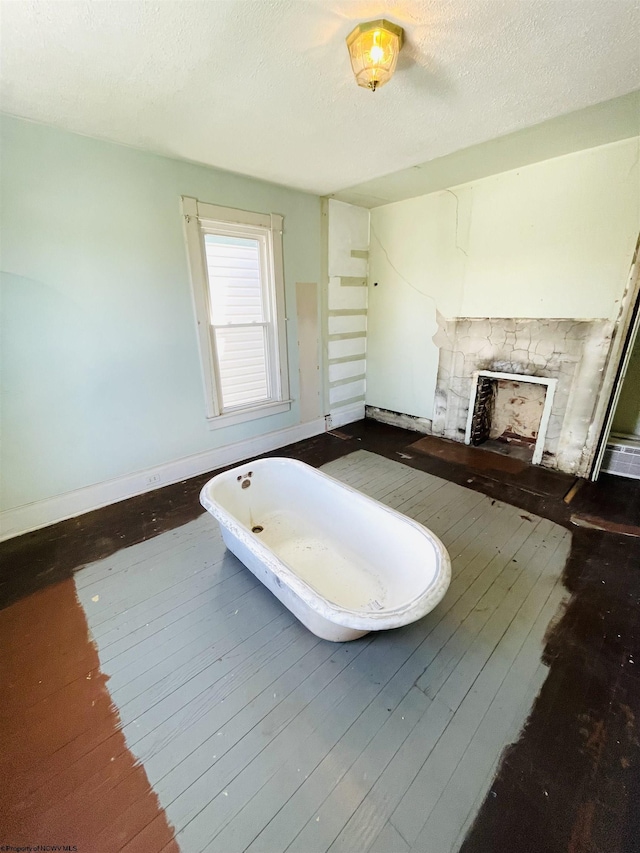 520 Mount Vernon Ave, Fairmont, WV 26554 - bathroom featuring a fireplace, baseboards, wood-type flooring, and a freestanding tub